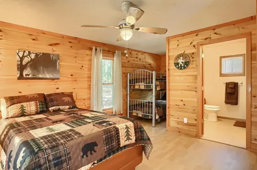 A bedroom with a queen bed and a set of bunk beds.