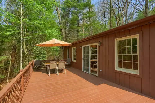 The spacious deck with a table covered by an umbrella.