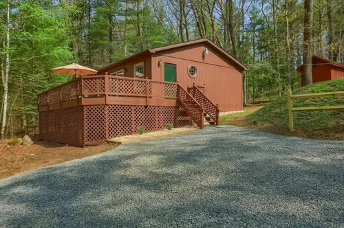 The exterior of the cabin showing the driveway and spacious deck.